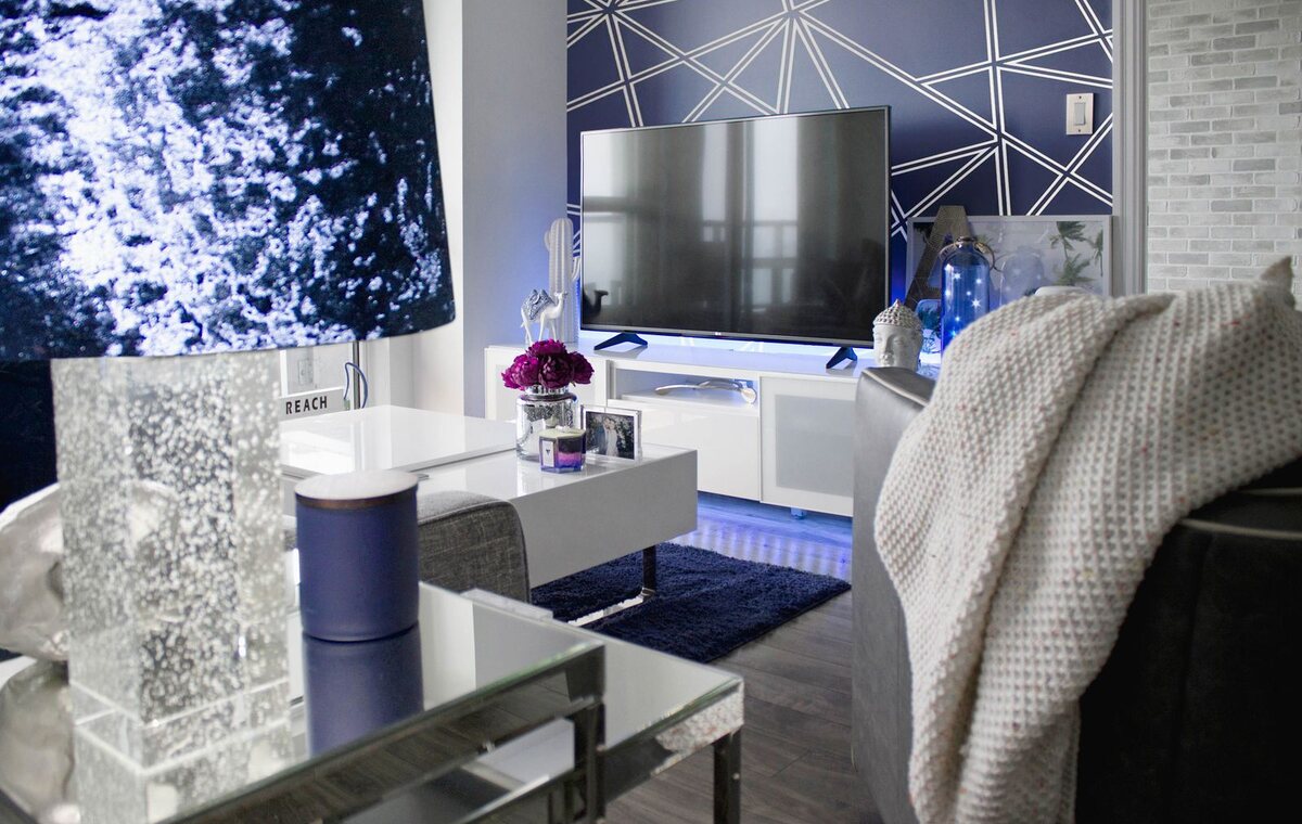 Living room with a bold blue geometric patterned wallpaper feature wall behind modern seating.